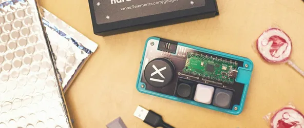 Material von GiftRush, dem Weihnachtsspiel von 9elements. Zu sehen ist die Verpackung des Spiels, zwei Lollipops, USB-Kabel sowie das selbst gebaute Pad.